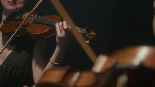 Women Play Violins in a Duet
