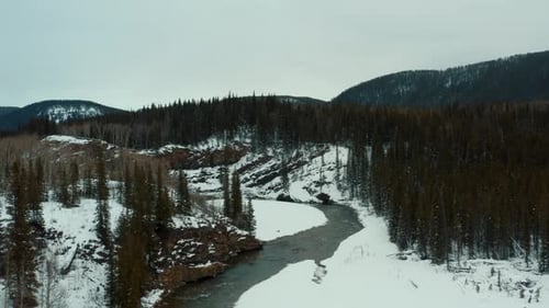 fly over meandering river, pristine winter landscape , trees and snow. Creek
