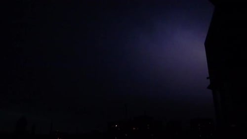 Flashes of lightning in the night sky among thunderclouds.