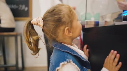 Young Child Standing at Counter in City Store