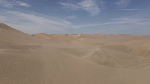 Aerial rises over huge wind sculpted sand dunes in Peruvian desert