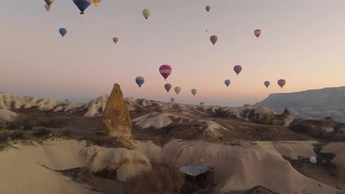 Drone view of hundreds of colorful hot air balloons soaring at sunrise in Cappadocia