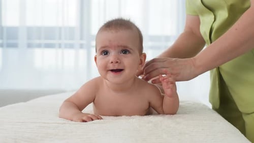 Infant Receiving Gentle Massage from Practitioner