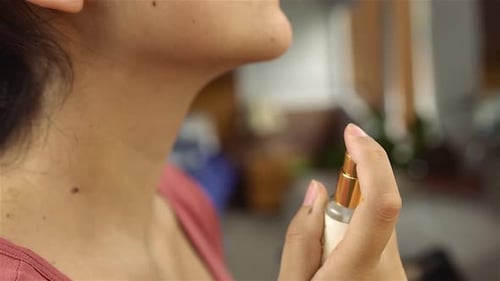 Woman Sprays Perfume on Neck in Close-Up