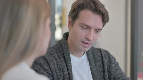 Gros plan d'un jeune homme en conversation avec une collègue
