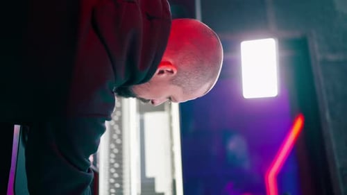 Vertical Video in the Recording Room Dark with Neon Lighting in the Studio the Sound Engineer Works