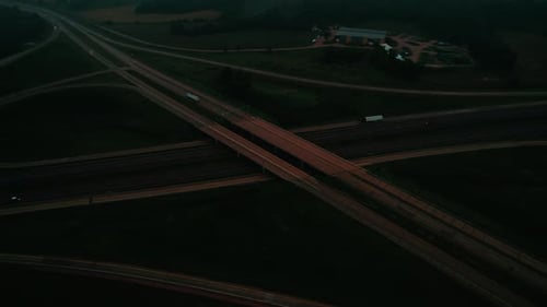 Aerial view of a solitary truck navigating a misty highway at night. Dark landscapes, atmospheric an