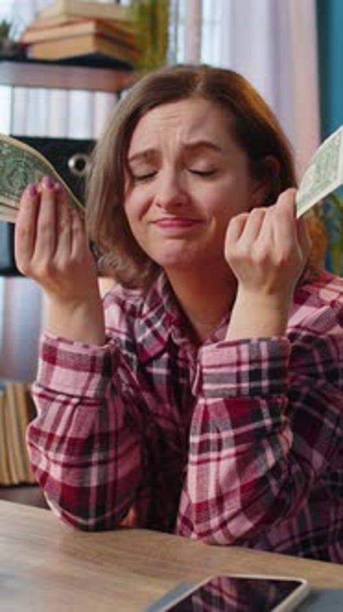 Sad Woman Counting Money in a Home Setting