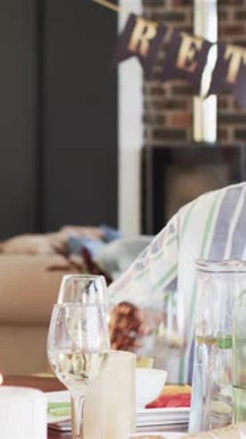 Vertical video: Senior African American man lifting wine glass rising to toast by retirement banner