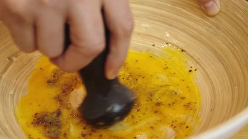 Mélanger les ingrédients pour la sauce à salade César dans un bol de cuisson profond. Plan rapproché au ralenti.