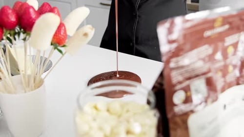 Chef Pouring Melted Chocolate Near Fruit Skewers