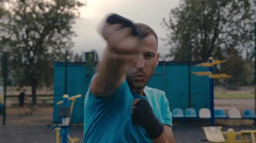 Adult Man Boxing Outdoors at City Park Workout
