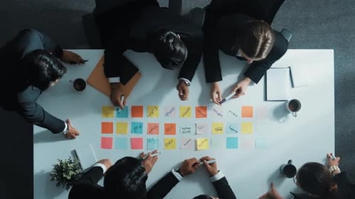 Corporate Team Brainstorming and Writing on Sticky Notes