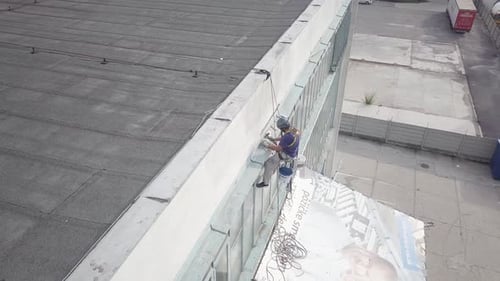 Descida aérea abatida para alpinista de alta altitude trabalhando na manutenção de edifícios de escritórios com segurança