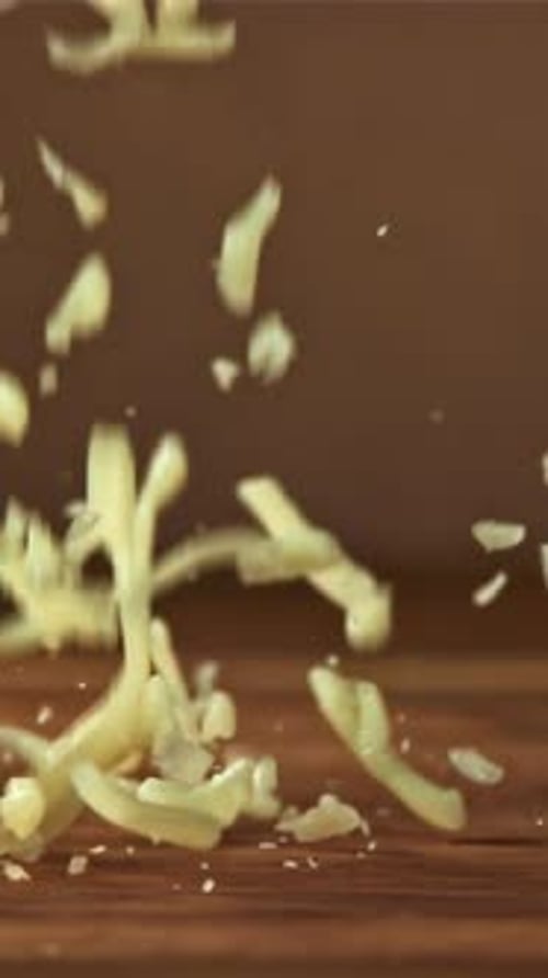 Grated Cheese Falls on a Wooden Board Filmed on a Highspeed Camera at 1000 Fps