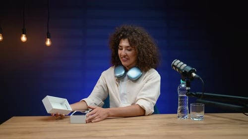 Woman Unboxing New Phone at Desk with Microphone
