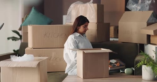 Woman Packing Belongings into Boxes for Moving
