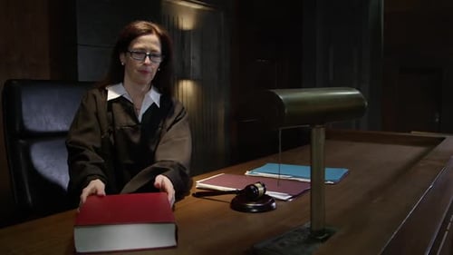 Woman Judge Reading Legal Book in Courtroom