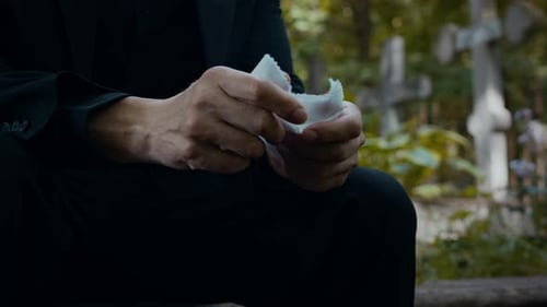 Hands of Man Clutching Handkerchief in Cemetery