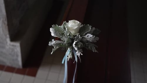 white rose floral decoration on church pew with ribbon