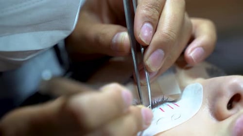 Woman with long eyelashes in a beauty salon. Eyelash extension procedure. Lashes close up 4K