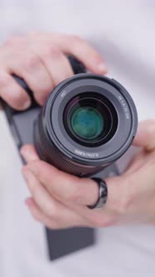 Vertical close up of person change aperture using lens ring, digital camera