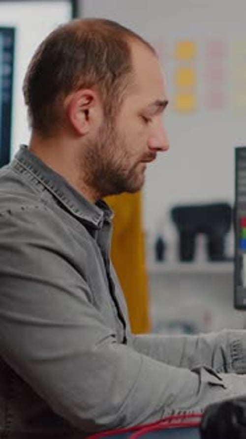 Bearded Man Smiling, Working at Computer in Office