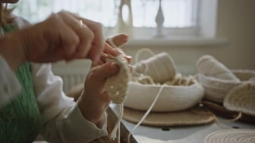 Woman Crocheting White Yarn Basket at Home