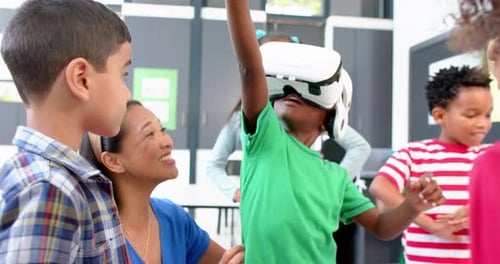 In school, children using VR headset with teacher guiding them in classroom