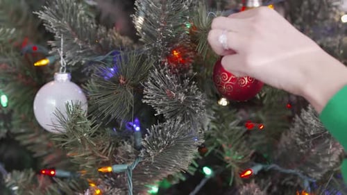 Accrocher une décoration de Noël sur un arbre de Noël