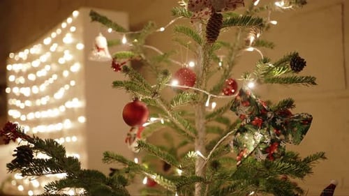 Decorated Christmas tree with warm fairy lights and festive ornaments indoors