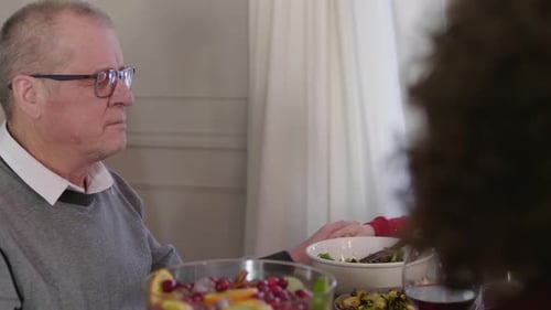 Family Holding Hands at Holiday Dinner Table