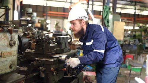 Fabrikarbeiter richtet CNC-Drehmaschine ein