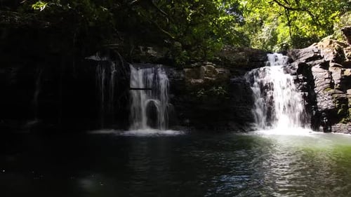 Slow aerial drone shot from left to right showcasing two waterfalls in a tropical forest, Costa Rica