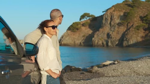 Couple Standing Beside Car at Beachfront Overlook
