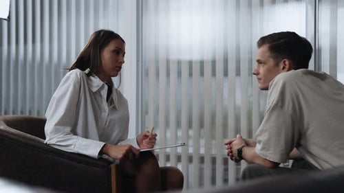 Woman Talks to Man in Modern Office Setting