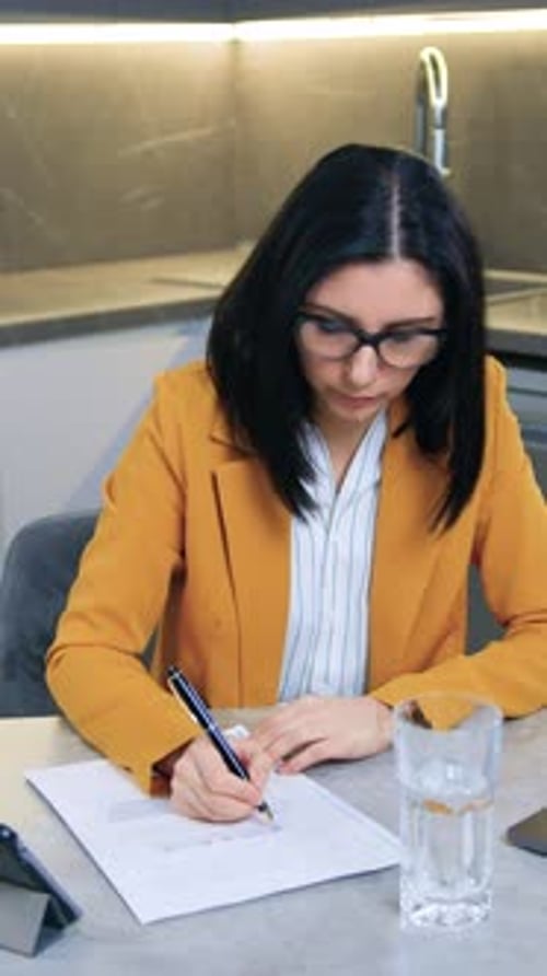 Woman in Blazer Working at Kitchen Table