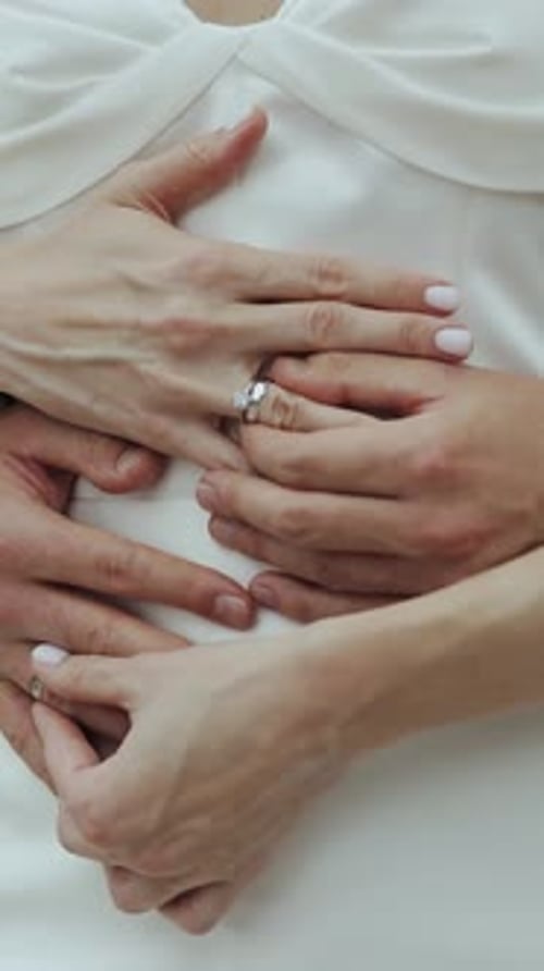 Primer plano de la novia y el novio intercambiando anillos de boda, personas irreconocibles, solo se ven las manos