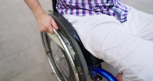 Man in Wheelchair Propels Himself Forward