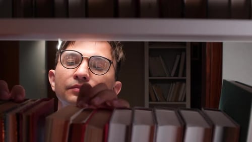 Librarian Searching Books on Library Shelf