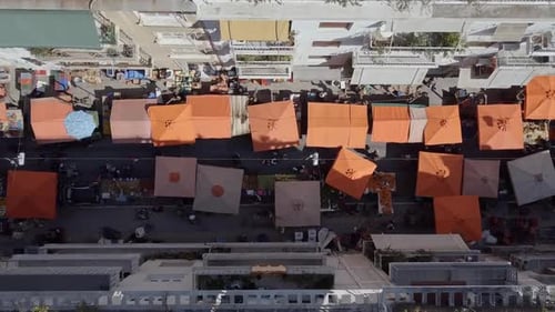 Aerial drone shot twisting over urban street market Exarcheia Athens Greece