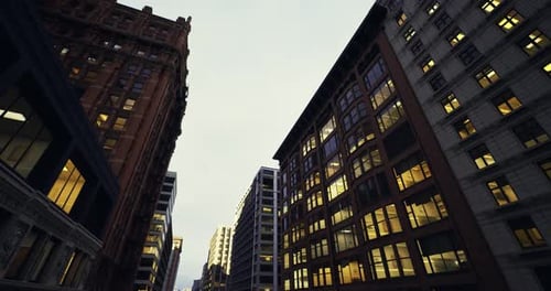Paisaje urbano nocturno que muestra estructuras imponentes y ventanas brillantes