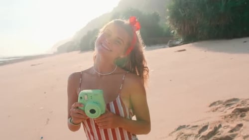 Young Caucasian Woman Teen Takes Pictures of you Stands on Sunny Seashore