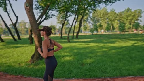 Woman Jogging on Path in Urban Park