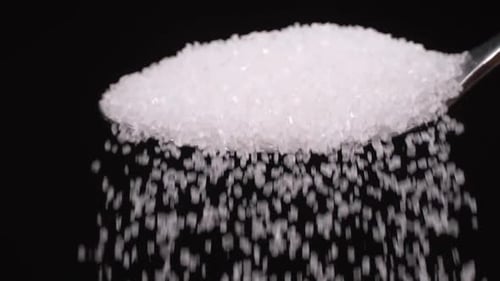 spoon full of powdered sugar crystals in teaspoon side view filled with sugar