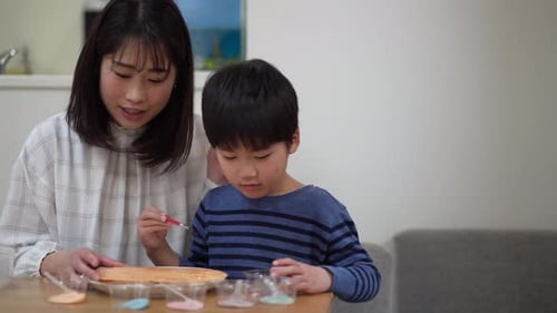 Woman and Child Painting Craft Together Indoors