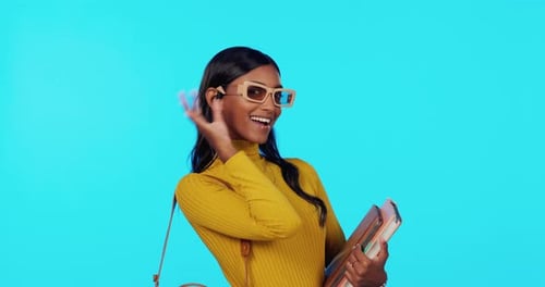 Stylish Woman Poses with Books Against Turquoise Background