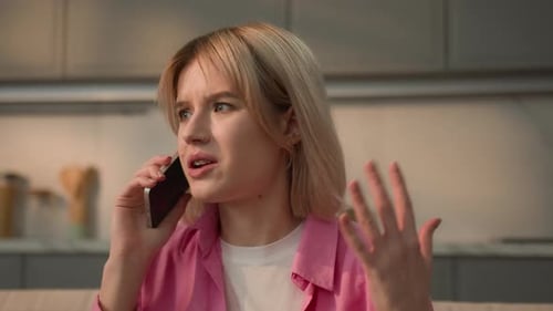 Upset Woman Talking on Phone Indoors