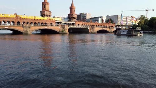 Famous Oberbaumbruecke in Berlin during Summer Day with Boats on River
