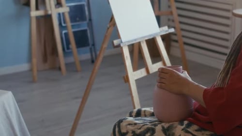 Female Artist with Disability Preparing to Draw Vase on Canvas in Studio